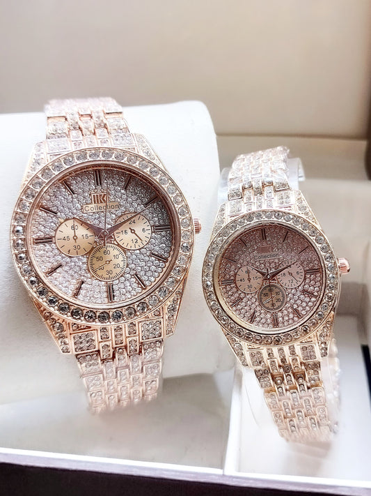 Two rose gold watches with diamond-studded straps on a white surface.
