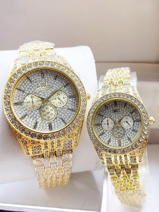 Two gold watches with diamond-studded faces on a white surface.